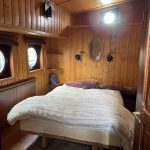 Image de la cabine avant située à gauche. Elle est composée d'un lit double situé au centre de la pièce.