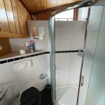 Photo de la salle de bain attenante à la cabine droite avec une douche et un toilette.