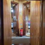 Image du passage vers les deux cabines situées à l'avant du bateau. Elles sont accessibles par un petit escalier en bois.