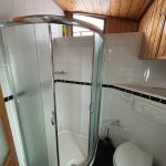 Photo de la salle de bain attenante à la cabine située à gauche. Elle comprend une douche spacieuse, des toilettes et un évier.