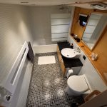 Image de la première salle de bain du bateau. Elle est assez grande et composée d'une baignoire, d'un évier et de toilettes.