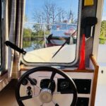 Vedette fluviale Jeanneau Eau Claire 930 Cassis (1985) – poste de pilotage intérieur et barre à roue