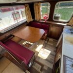 Pénichette Locaboat 930 Sérénité (1981) – coin salon-cuisine avec table et évier
