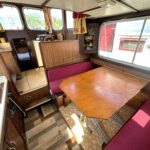Pénichette Locaboat 930 Sérénité (1981) – carré avec table et banquettes bordeaux