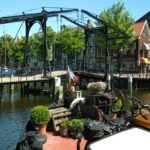 Péniche Hagenaar 18 m ANNA (1911) – vue extérieure amarrée devant un pont-levis néerlandais