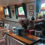 Péniche Hagenaar 18 m ANNA (1911) – coin repas du salon avec cuisine en enfilade