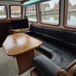 Kotter hollandais Bronsveen 1480 Petit Michou (2002) – salon, banquette cuir et table