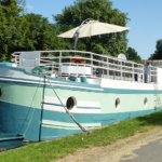 Péniche Freycinet 30 m Au Fil de l'Eau (1956) – étrave bâbord et pont avant avec parasol