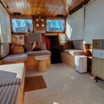 Vedette hollandaise Helena Cruiser (1980) – salon avec barre à roue et banquettes