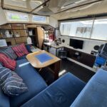 Vedette fluviale Connoisseur 1135 Ingrine (1986) – salon avec dinette et téléviseur