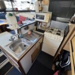 Vedette fluviale Connoisseur 1135 Ingrine (1986) – cuisine avec évier, cuisinière gaz et micro-ondes
