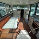 Vedette fluviale Nicols 1100 Lodève (1998) – carré avec table face à la cuisine