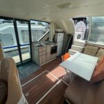 Vedette fluviale Nicols 1100 Lodève (1998) – carré, cuisine et accès au pont arrière