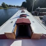 Péniche Luxe-Motor Dulcinea (1929) – pont avant avec écoutilles sous tauds rouges et descente ouverte