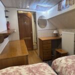 Péniche Luxe-Motor Dulcinea (1929) – cabine à deux lits avec commode, coiffeuse et porte en bois