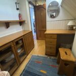 Péniche Luxe-Motor Dulcinea (1929) – rangements de la cabine : buffet vitré, bureau en bois et tabouret