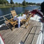 Péniche Luxe-Motor Dulcinea (1929) – coin repas sur le pont avant, table dressée face à la proue