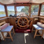 Péniche Luxe-Motor Dulcinea (1929) – intérieur de la timonerie avec barre à roue en bois