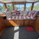Péniche Luxe-Motor Dulcinea (1929) – banquette à coussins rayés dans la timonerie vitrée