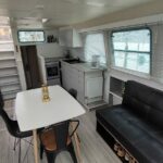 Vedette hollandaise Vetus 1200 Damier (1992) – coin repas du carré avec banquette et cuisine ouverte