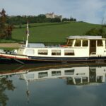 Péniche Luxe-Motor 14,50 m (1928) – vue extérieure au canal devant un château