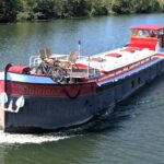 Péniche Luxe-Motor Dulcinea (1929) – vue aérienne en navigation, proue et pont soleil