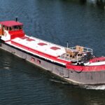 Péniche Luxe-Motor Dulcinea (1929) – vue aérienne trois-quarts avant en navigation, terrasse sur le pont avant